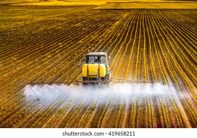 Tractor Spraying A Field Of Corn