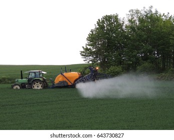 Tractor spraying fields with pesticides