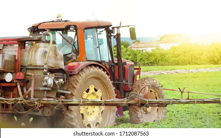 Tractor spraying pesticide, pesticides or insecticide spray on lettuce or iceberg field at sunset. Pesticides and insecticides on agricultural field in Spain. Weed insecticide fumigation. Organic