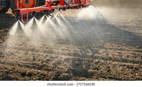 Tractor spraying pesticides on field  with sprayer 