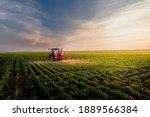 Tractor spraying pesticides on soy field  with sprayer at spring