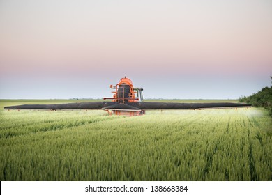 Tractor spraying wheat in the spring - Shutterstock ID 138668384