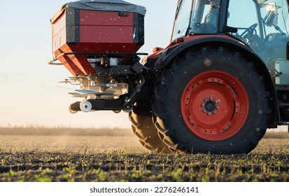 Tractor spreading artificial fertilizers. Transport, agricultural. - Shutterstock ID 2276246141