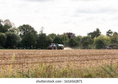 A Tractor Spreading Slurry, Fertilizer On The Field Ready To Plant New Crop