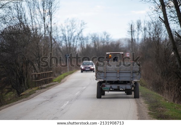 Tractor with a\
trailer driving on the\
road.