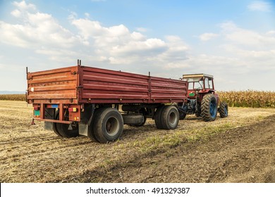 Tractor With Trailer Standing In A Field Waiting For Harvest