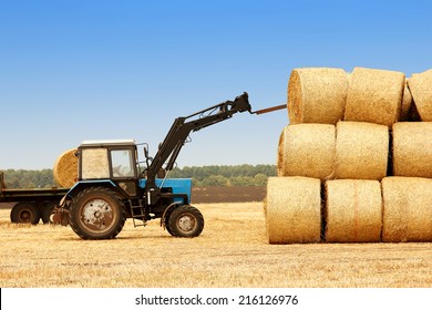 Tractor Unloads Bales Of Hay In The Field