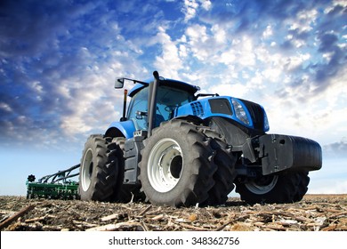 The tractor wheels on the huge field, a farmer riding a tractor, a tractor working in a field agricultural machinery in the work, tractor in the background cloudy sky - Shutterstock ID 348362756