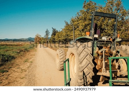 Tractor Winds Down Dirt Road On The Way To Harvest Crops On Farm in Fall in Willamette Valley