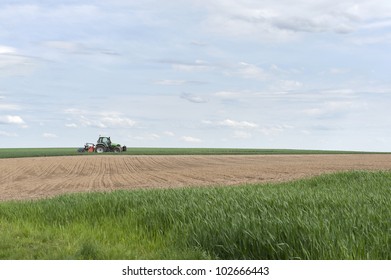 tractor working in the fields against a blue sky