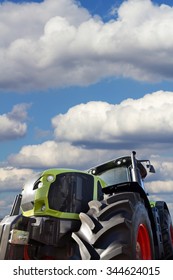 Tractor Working On The Farm, A Modern Agricultural Transport, A Farmer Working In The Field, Tractor In The Background Cloudy Sky, Modern Tractor Closeup