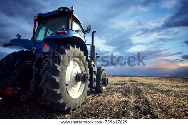 Tractor working on\
the farm, a modern agricultural transport, a farmer working in the\
field, tractor at sunset, fertile land, modern tractor closeup,\
cultivation of land
