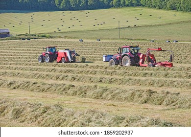 Tractors And Bale Wrapper Baling Hay In Field