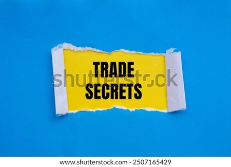 Trade secrets message written on ripped torn blue paper with yellow background. Conceptual trade secrets symbol. Copy space.