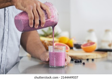 Trade your boring breakfast for a nutritional shake. Cropped shot of a man pouring a freshly blended smoothie into his glass at home. - Powered by Shutterstock