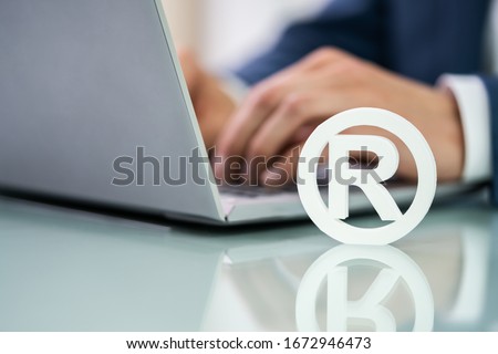 Trademark Sign Near Man's Hand Working On Laptop