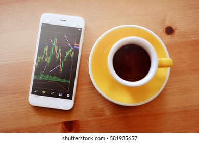 Trader Have Monitoring Stock Market Chart On Mobile Phone In Coffee Cafe.