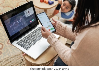 Trader Mother Studying Stock Market On Streaming Lesson With Her Child At Home - Blockchain Analysis Concept - Focus On Left Hand Holding Mobile Phone