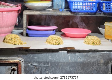 The trader is preparing the process of making freshly cooked fried rice with a fragrant aroma and an appetizing appearance.