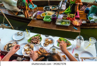 Trader's boats in a floating market in Thailand. Floating markets are one of the main cultural tourist destinations in Asia. - Powered by Shutterstock