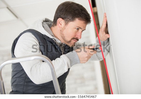 tradesman joining sheets\
of plasterboard