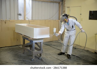 Tradesman Spray Painting A Coffin In A Spray Booth