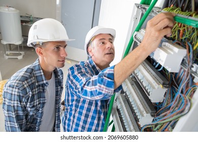 tradesmen installing a distribution board