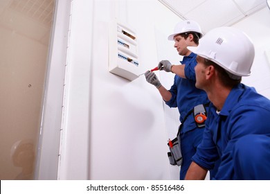 Tradesmen installing a distribution board