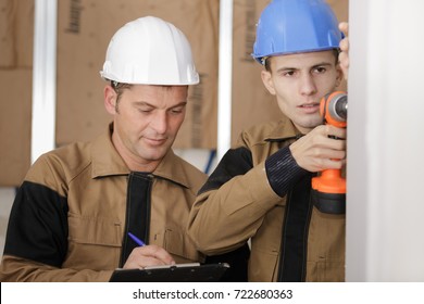 tradesmen installing drywall