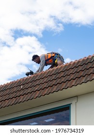 Tradie Working On Tile Roof. Auckland, New Zealand - May 13, 2021