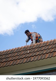 Tradie Working On Tile Roof. Auckland, New Zealand - May 13, 2021