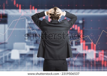 Trading, investing crash and economy crisis concept with confused man back view grabs his head and looks on virtual screen with declining digital red financial chart candlestick and graphs