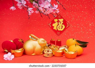 Tradition Chinese golden rabbit statue,2023 is year of the rabbit,Chinese golden characters Translation:good bless for year of the rabbit,word on golden coin Translation:good luck for money - Shutterstock ID 2233731037
