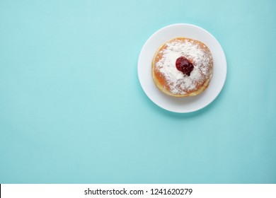 Tradition Jewish Holiday Sweets, Donut Sufganioyt With Sugar Powder And Jam Top View On Blue Background With Copy Space.