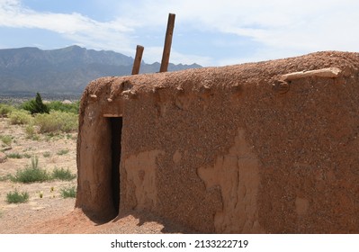 Traditional Adobe Home From The Kuaua Pueblo In New Mexico With The Sandia Mountain Range In The Background.