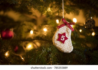 Traditional Advent Calendar Stocking with the date of the fifth of December hanging on a traditional christmas tree.