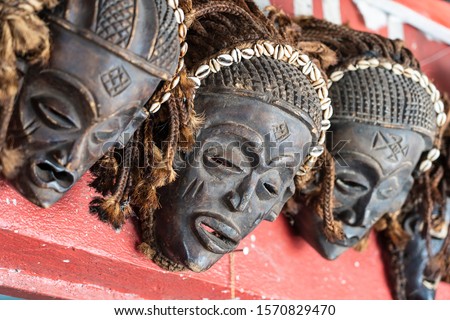 Traditional african wooden masks hanging for sell on the street market on the island of Zanzibar, Tanzania, East Africa, close up