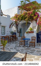 Traditional alley with whitewashed houses,an exterior of a greek tavern  and a  bougainvillea in Prodromos Paros island - Shutterstock ID 2114846042