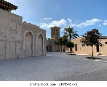 Traditional Alleyway In Dubai's Historic District, With An Iconic Windtower In The Distance, Pictured On A Summer's Day