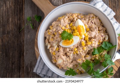 Traditional American Tuna Salad With Mayonnaise, Corn, Onions And Boiled Eggs. Served In A Rustic Bowl Isolated On Wooden Table With Copy Space