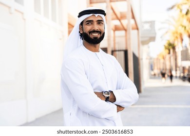 Traditional arab man wearing emirati kandura outdoors - Handsome middle-eastern adult male businessman portrait in the city - Powered by Shutterstock