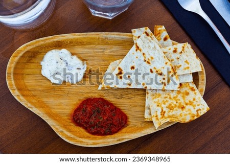 Traditional Arabian appetizer of toasted flatbread served with spicy tomato sauce and piquant garlic tomeya sauce Сток-фото © 