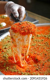 Traditional Arabian red kunafa, konafa with Cream and Cheese with pistachio nuts on top
