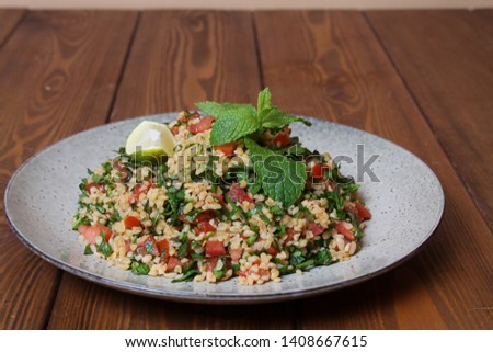 Traditional arabic Ramadan food Tabbouleh salad from bulgur, mint, parsley, tomatoes, lime.