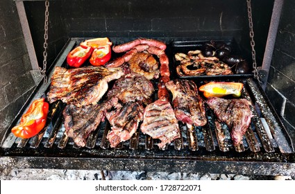 Traditional argentinian food barbeque (asado) grilled with a lot of beef, pork, achuras and red bell peppers with eggs.