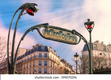 Traditional Art Nouveau entrance sign for the Metropolitan and red streetlights, typical Parisian buildings in the background, Paris, France. - Powered by Shutterstock