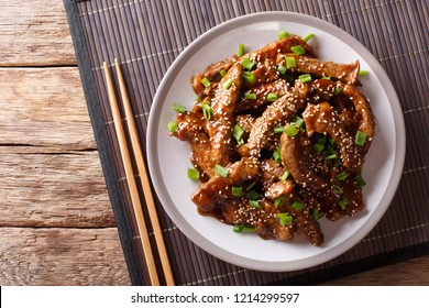 Traditional Asian Beef Teriyaki With Green Onions And Sesame Close-up On A Plate On The Table. Horizontal Top View From Above
