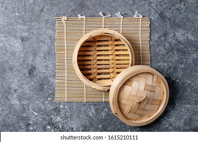 Traditional asian kitchen utensil bamboo steamer over blue texture background. Top view, flat lay. Copy space