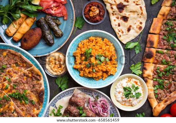 Traditional assorted turkish dishes. Turkish pizza,\
meat kebab, pita, bulgur, fried meatballs, hummus and turkish meze\
set. Middle eastern dinner. Food party. Turkish cuisine. Top view.\
Eastern food