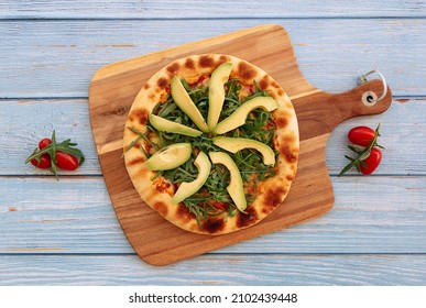 Traditional Avocado Rockets Pizza with tomatoes colorful toppings in wood background top view - Powered by Shutterstock